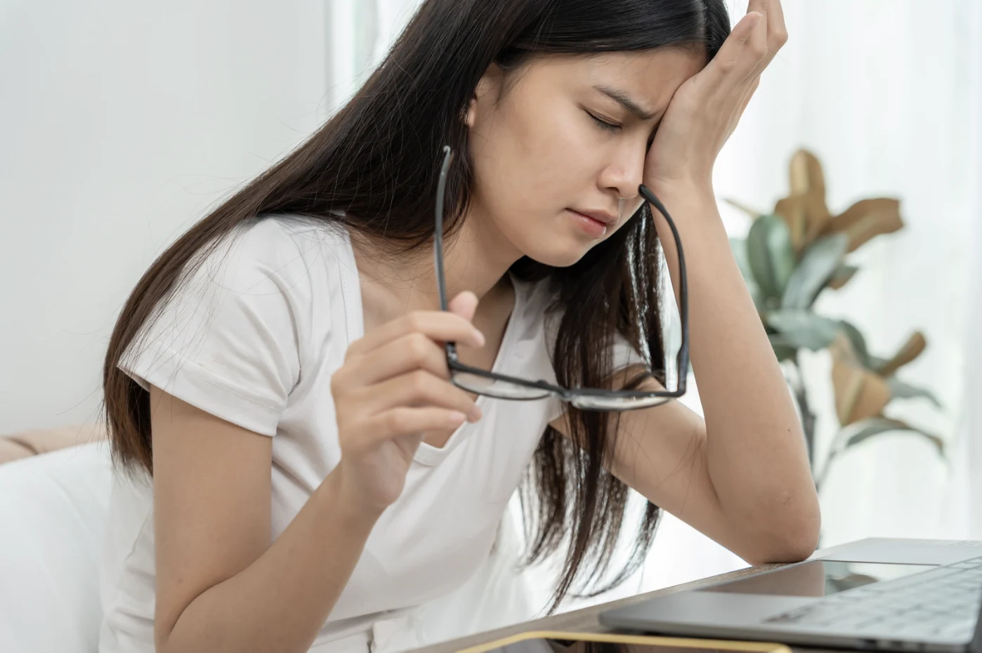 Asian woman holding her eyes due to dry eyes