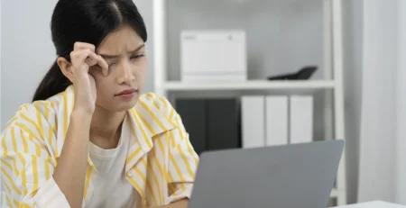 Asian woman rubbing her eyes due to dry eyes in Singapore.