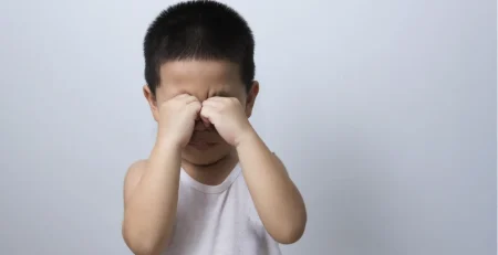 Asian child rubbing his eyes, a habit often from a common eyelid condition called epiblepharon