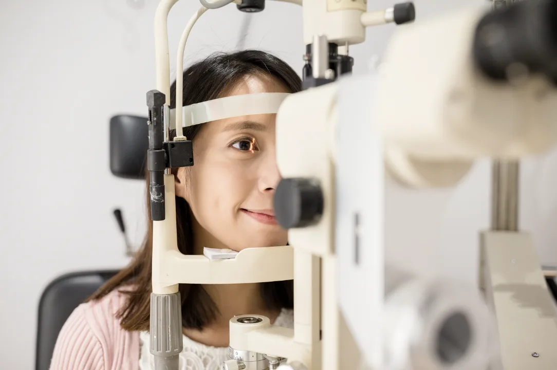 Young Asian woman undergoing a slit lamp exam during a glaucoma screening in Singapore.